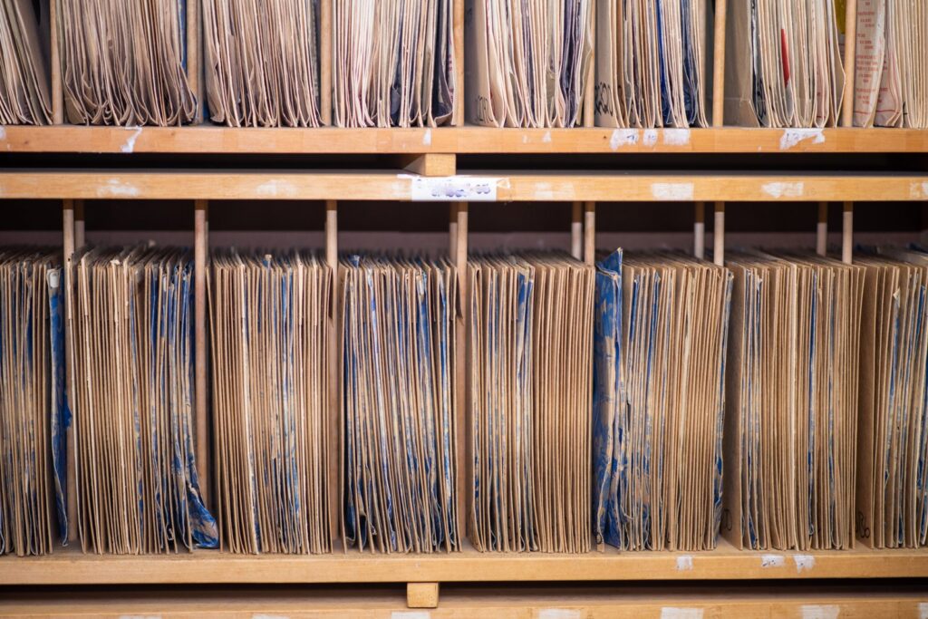 Compliant digital preservation: archive shelves full of old paper folders