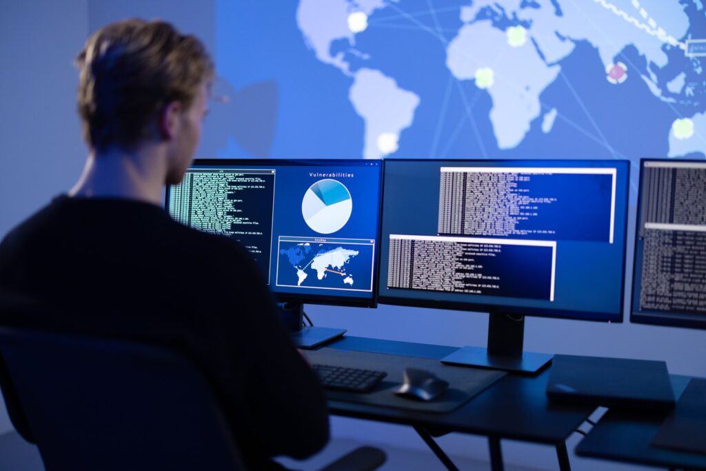 Operatore di un SOC monitora gli eventi su piu schermi: sicurezza gestita per le PMI