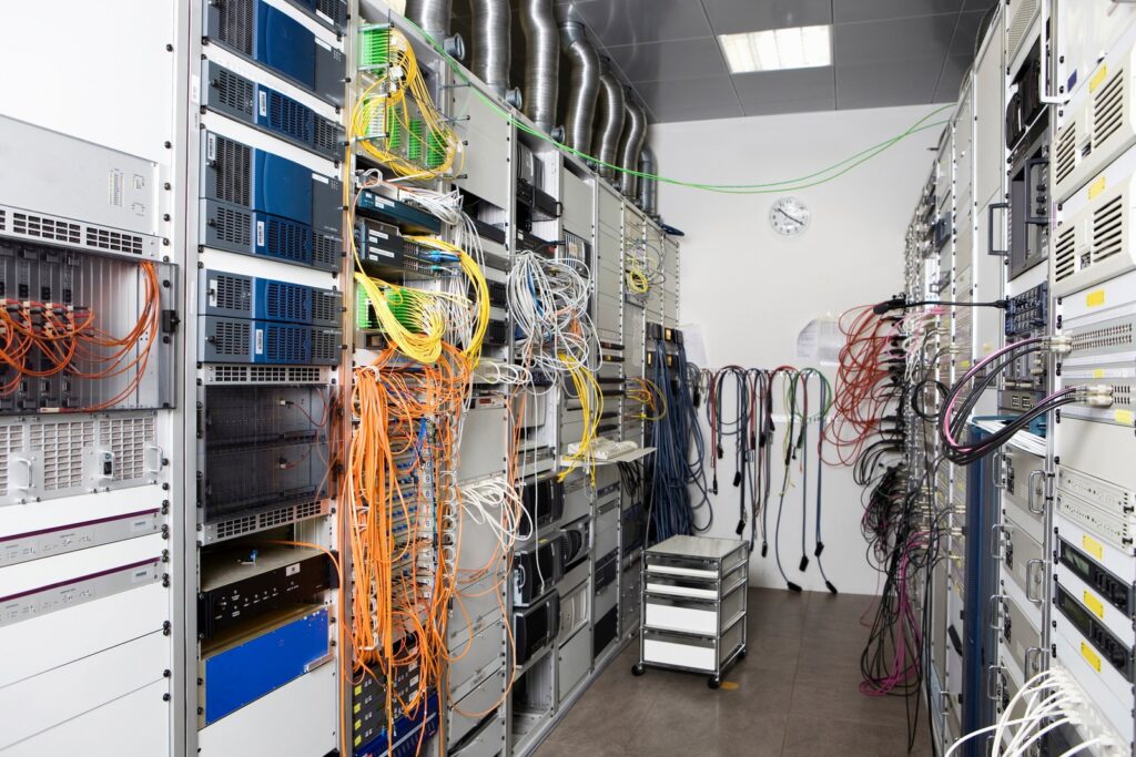 Sala macchine di un'azienda con armadi rack e cablaggi in rame e fibra
