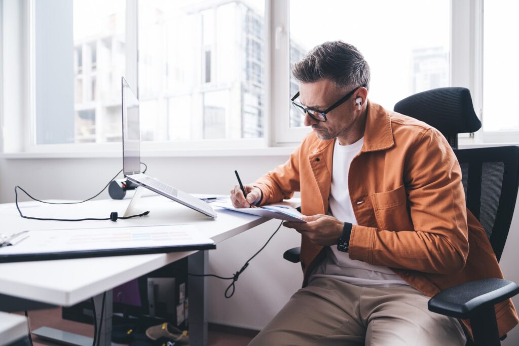NIS2 compliance: a manager filling in a customer security questionnaire by hand at an office desk