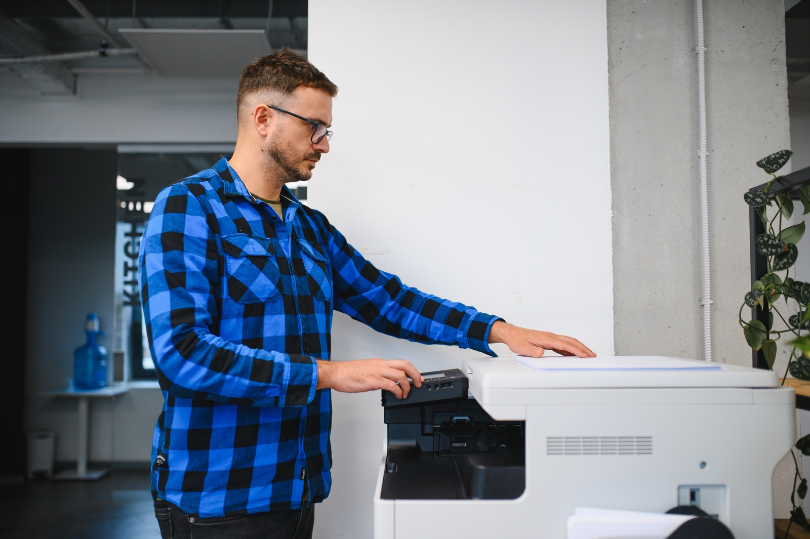 Onboarding del nuovo dipendente: un impiegato stampa i documenti di assunzione alla multifunzione dell'ufficio